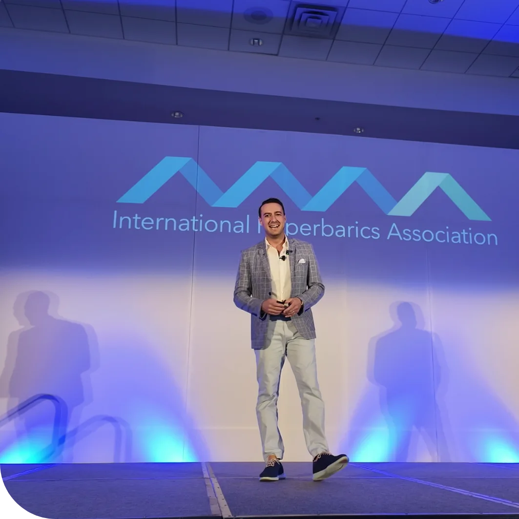 Dr. Alexander Borsand on stage at an International Hyperbarics Association event